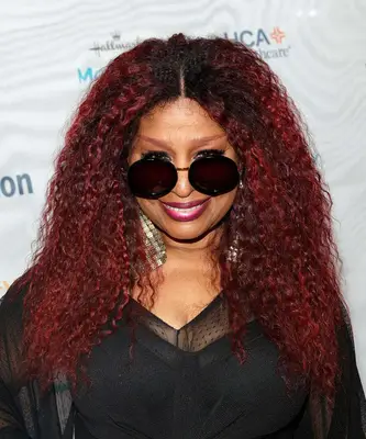 Chakra Khan with long, dark red natural hair