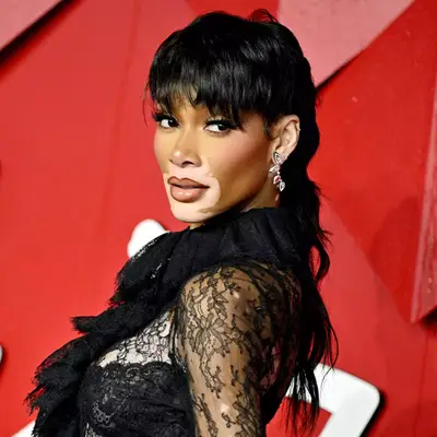 Winnie Harlow poses over the shoulder with a choppy and exaggerated mullet haircut