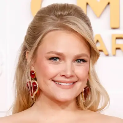 Hailey Whitters wears a classic half-up style hairstyle and side bangs on the CMA red carpet