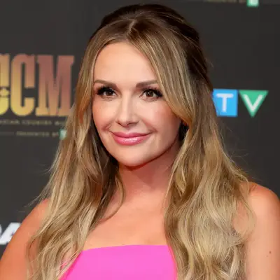 Carly Pearce wears a half up hairstyle to the Canadian CMAs with a glossy lip and bright pink strapless dress