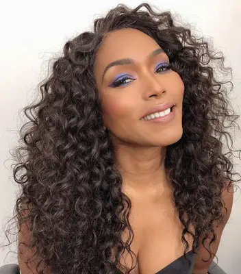 Angela Bassett with curly hair and bold blue eyeshadow