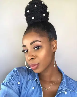 A woman taking a selfie wearing a topknot with pearls studded all over
