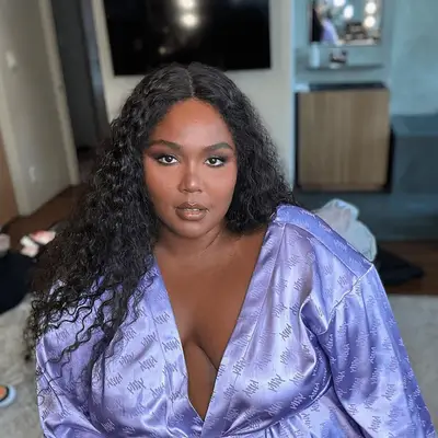 Lizzo with wavy hair with center part