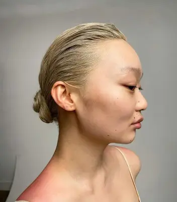 A woman with platinum blonde hair wearing a wet chignon hairstyle