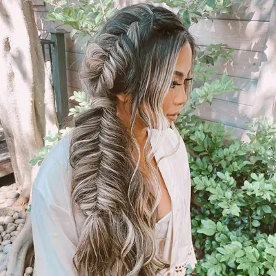A woman wearing a long, chunky fishtail braid