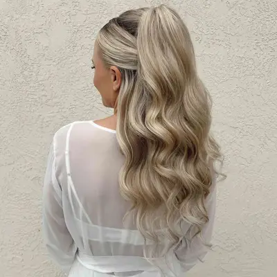 A woman with a wavy half-up, half-down blonde hairstyle