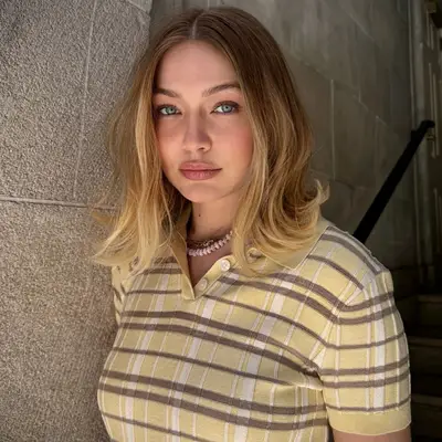 Gigi Hadid standing outdoors wearing a patterned shirt