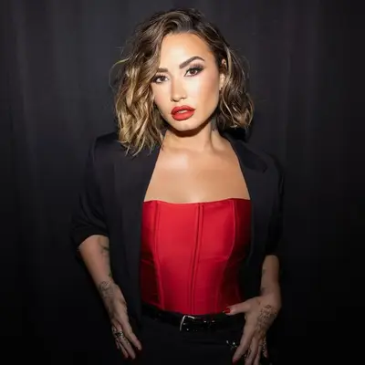 Demi Lovato posing against a black background