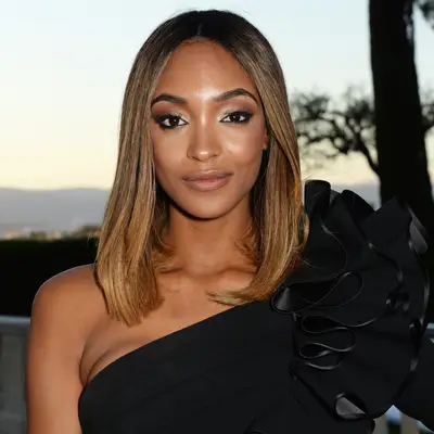 Jourdan Dunn in a black dress with ruffled detail, outdoors at sunset