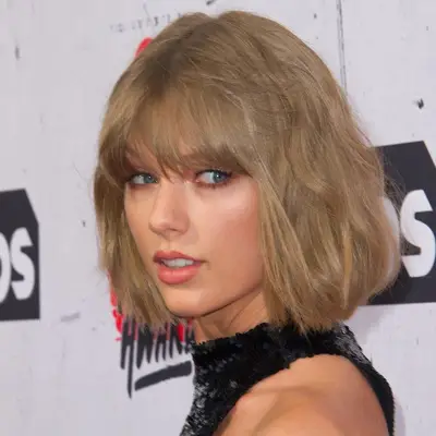 Taylor Swift wears a dirty ash blonde bob with bangs