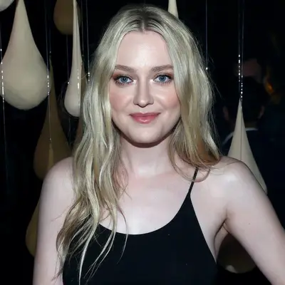 Dakota Fanning wears light ash blonde wavy long hair and dewy makeup