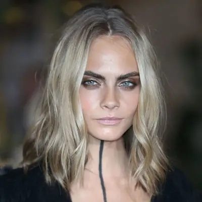 Cara Delevingne wears subtle ash blonde hair with dark blonde roots