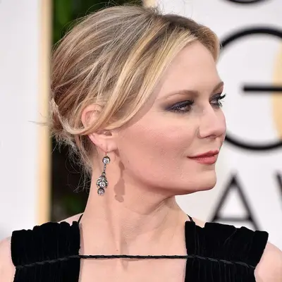 Kirsten Dunst wears ash blonde highlighted hair in an updo