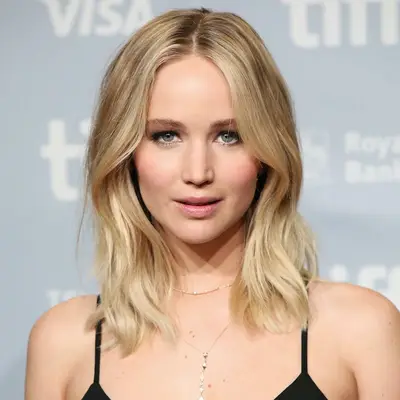Jennifer Lawrence wears medium-length ash blonde hair with center part