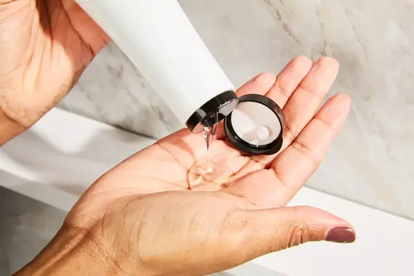 A person pouring the Shu Uemura Izumi Tonic Strenghtening & Thickening Rice Water Shampoo into their hands