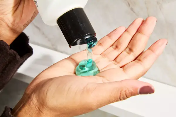 A person pouring Nioxin System 1 Shampoo into their hand