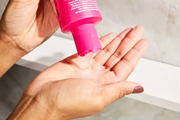 A person pouring the Viviscal Thickening Shampoo in their hand