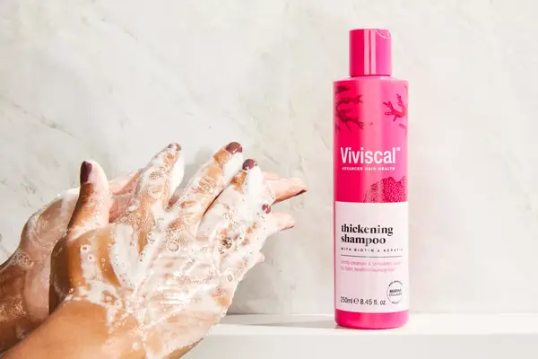 a person lathering the Viviscal Thickening Shampoo in their hands