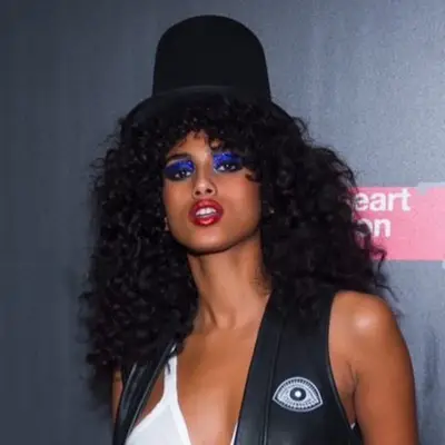 Imaan Hammam wears a Slash-inspired Halloween look with top hat and curly hair