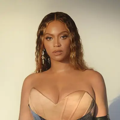 Close up of Beyonce, viewed from the shoulders up, her hair center-parted in subtle crimps