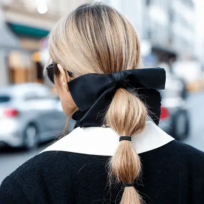 Katy Perry wears a low, sleek bubble ponytail adorned in a silver coiled accessory