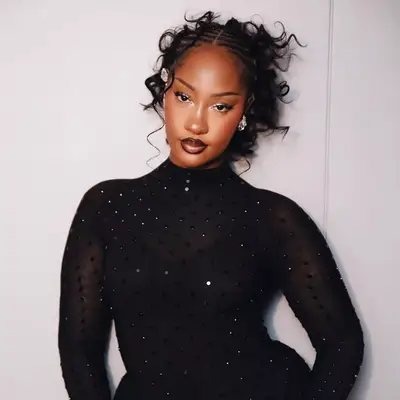 Tems wearing cornrows in the front and curly ponytail