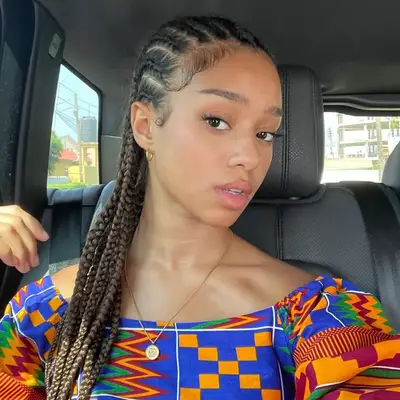 Meret Manon with braided hairstyle sitting in a car