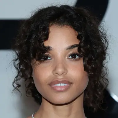 Ella Balinska wears her long curtain bangs in a natural tousled curl layered down around her face during NYFW