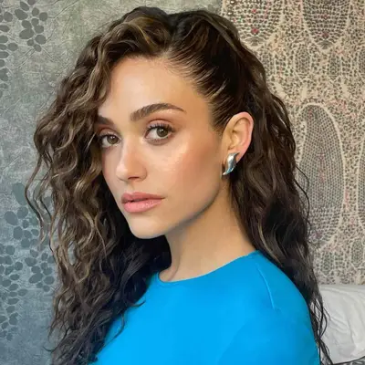 Emmy Rossum wears wavy hair in a deep side part
