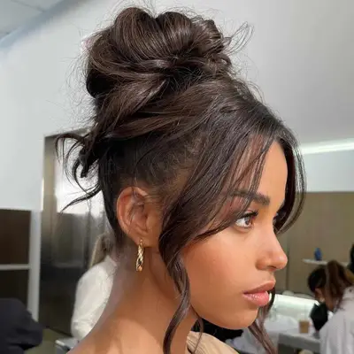 Ella Balinska wears a super high ballerina bun with face framing curls