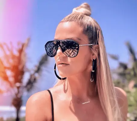 Khloe Kardashian wearing a high contrast top knot against extra long strands