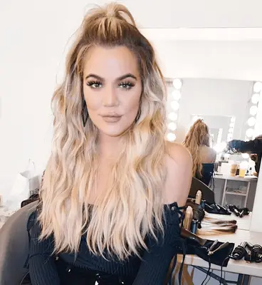 Khloe Kardashian in a half-up wavy hairstyle