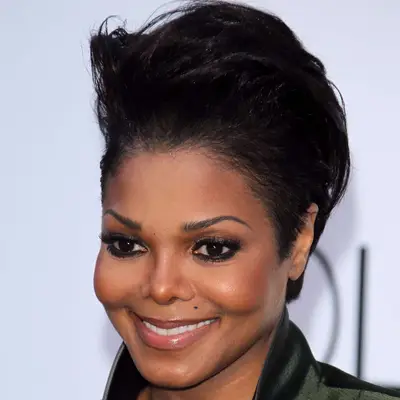 Janet Jackson wears a short pompadour hairstyle and radiant neutral makeup