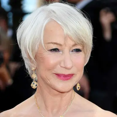 Helen Mirren wears a short hairstyle with soft, face-framing bangs