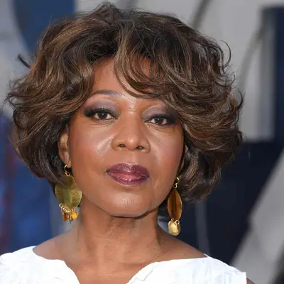 Alfre Woodard wears a voluminous wavy short bob hairstyle with bangs