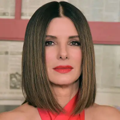 Sandra Bullock wears a long bob hairstyle with caramel highlights