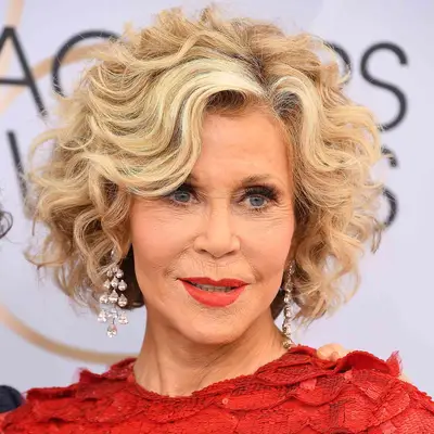 Jane Fonda wears a bob-length curly hairstyle