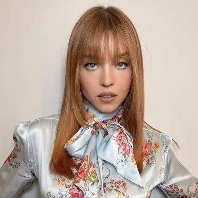 Sydney Sweeney with red hair and blunt bangs