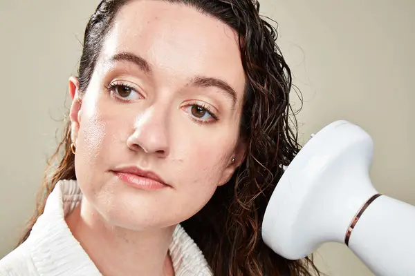 A woman dries her hair 