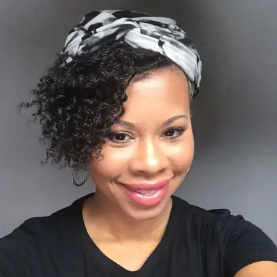 Woman wears mini twists hairstyle with head wrap