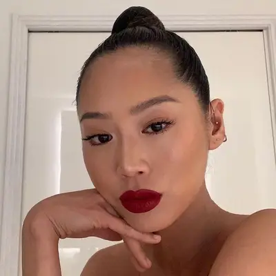 Aimee Song wears a sleek high bun hairstyle