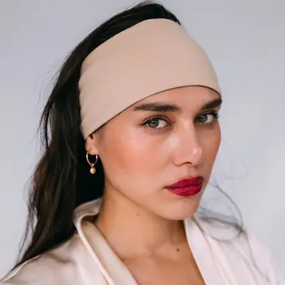 Natalie Suarez wears a wide headband and red lipstick