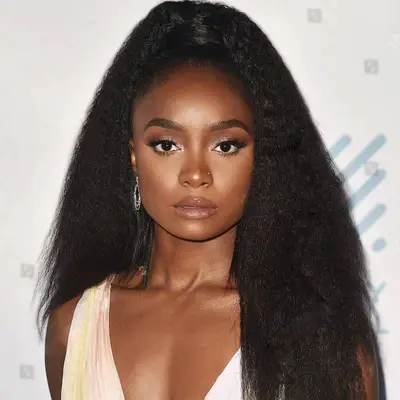 Kiki Layne wears a wrapped high ponytail hairstyle with natural texture