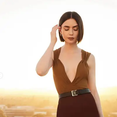 Lily Collins with a short bob hairstyle and brown dress