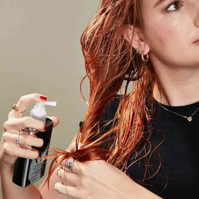 Woman adds heat protectant to her wet hair