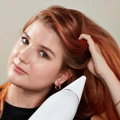 Woman blow dries her hair