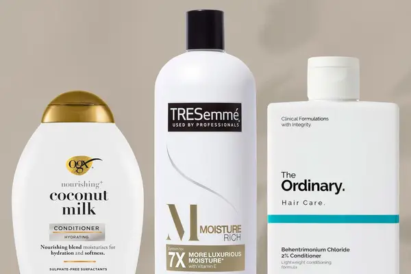 Side-by-side selection of drugstore conditioners, including picks from OGX, Tresemmé, and The Ordinary, on a beige background
