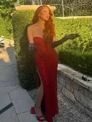 mariah carey dressed up as jessica rabbit for halloween with red curly wig, red dress, black gloves