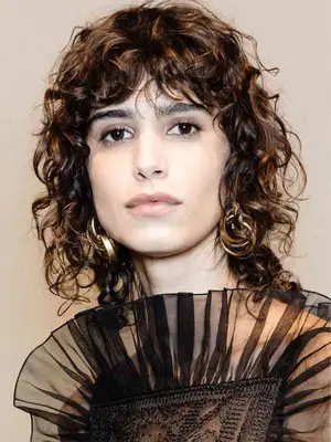 model with curly curtain bangs