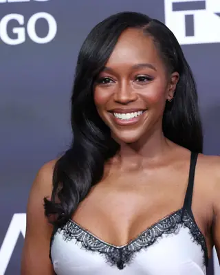 Aja Naomi King with loose waves and sleek hair